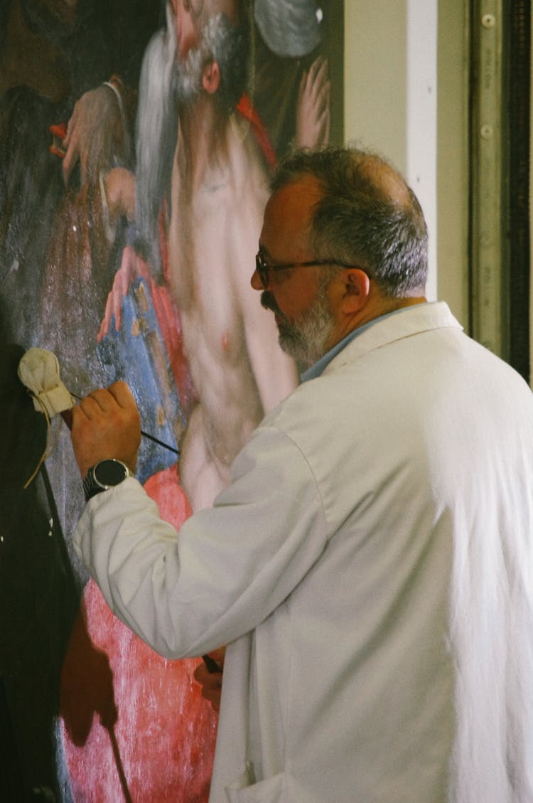 Man Fixing A Painting