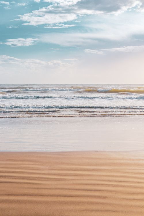Free Tranquil view of a Greek beach with gentle waves and clear sky, perfect for relaxation and travel inspiration. Stock Photo