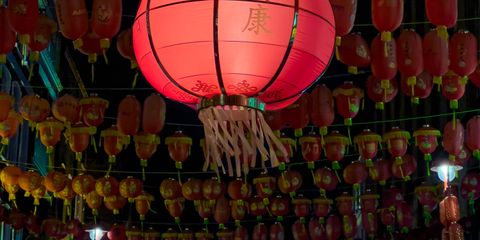 Vibrant red Chinese lanterns illuminate a London street, showcasing traditional culture in an urban setting.
