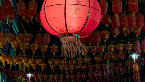 Vibrant red Chinese lanterns illuminate a London street, showcasing traditional culture in an urban setting.