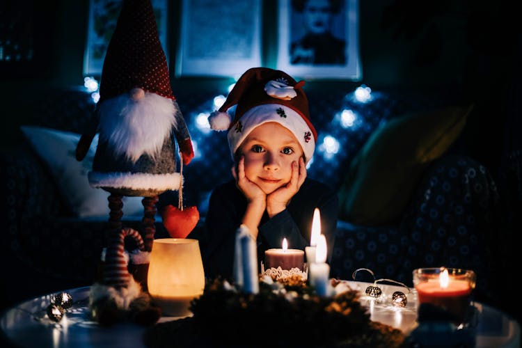 Child In Santa Hat By Decorated Table