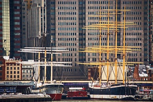 Black White and Yellow Boat Beside Gray Red and White Boat