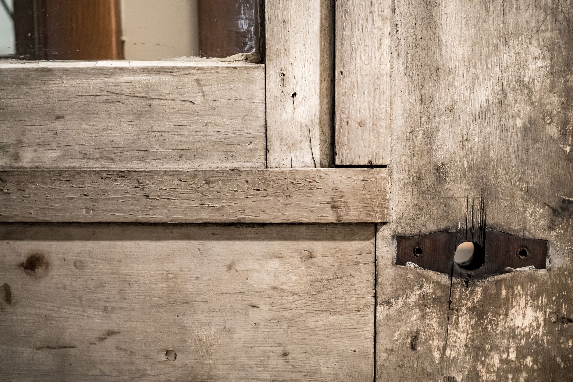Close-up of an old, weathered wooden door with rusty hinges, showcasing vintage charm.