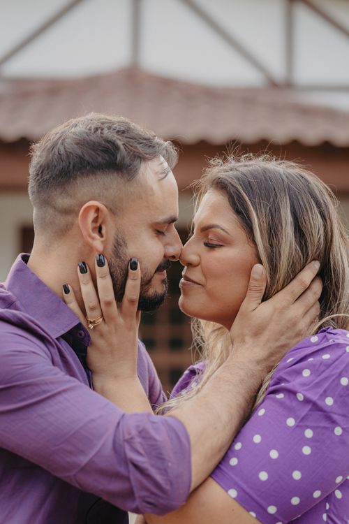 Free A loving couple shares an intimate moment outdoors in matching purple shirts. Stock Photo
