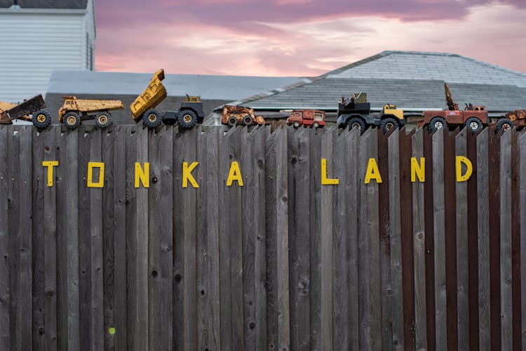 Toys Cars And Trucks On Fence