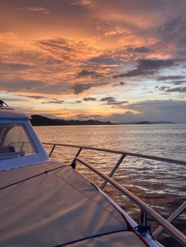 Capture the serene beauty of a sunset over calm waters from the deck of a luxury yacht.