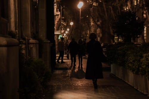 Pedestrians on Sidewalk at Night