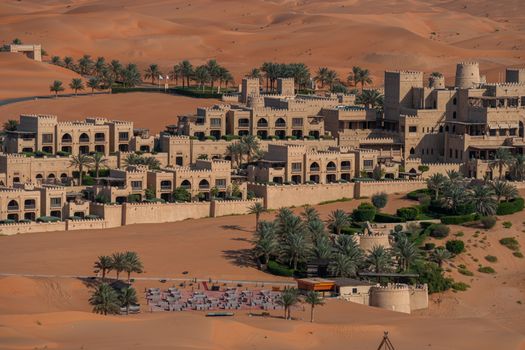 Aerial view of a luxurious resort amidst the Abu Dhabi desert, showcasing traditional architecture.
