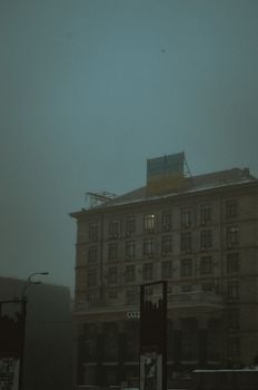 Atmospheric view of a building in Kyiv on a foggy day, capturing a moody and dramatic urban scene.