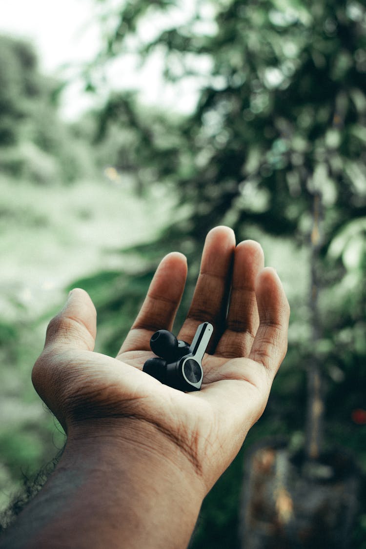 Man Holding Wireless Earphones