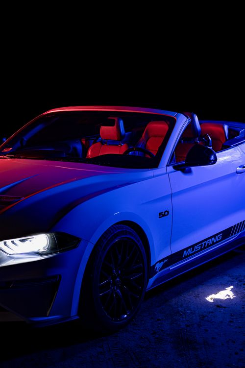 Free A luxury Ford Mustang convertible with striking neon lighting for a dynamic night showcase. Stock Photo