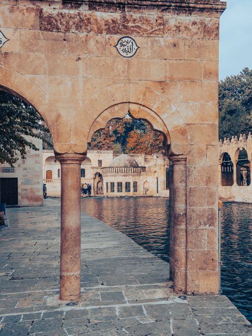 Free Explore the historic arches and scenic beauty of Şanlıurfa, Türkiye. Captured in a serene courtyard setting. Stock Photo