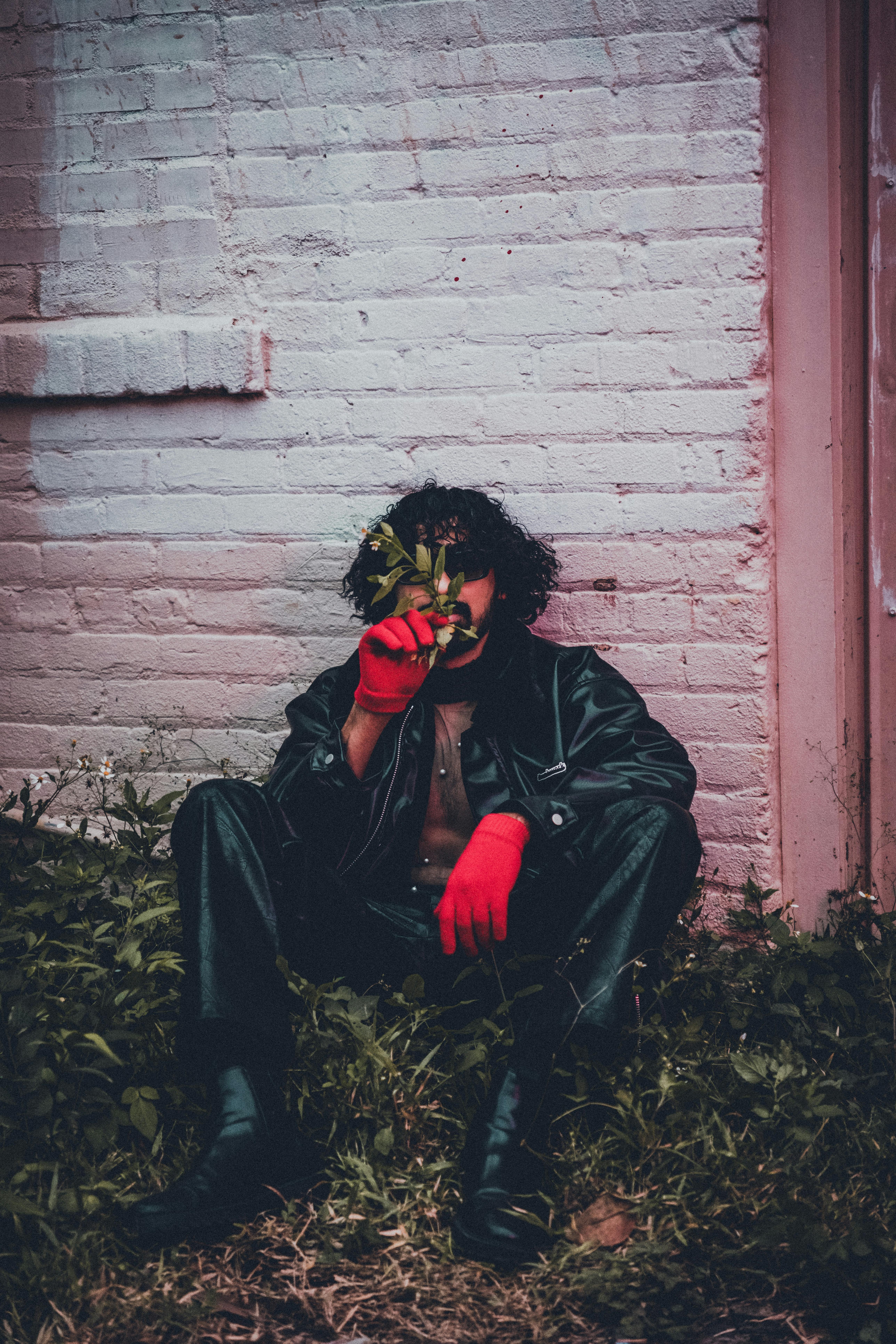 a man in red gloves and a red jacket sitting on the ground