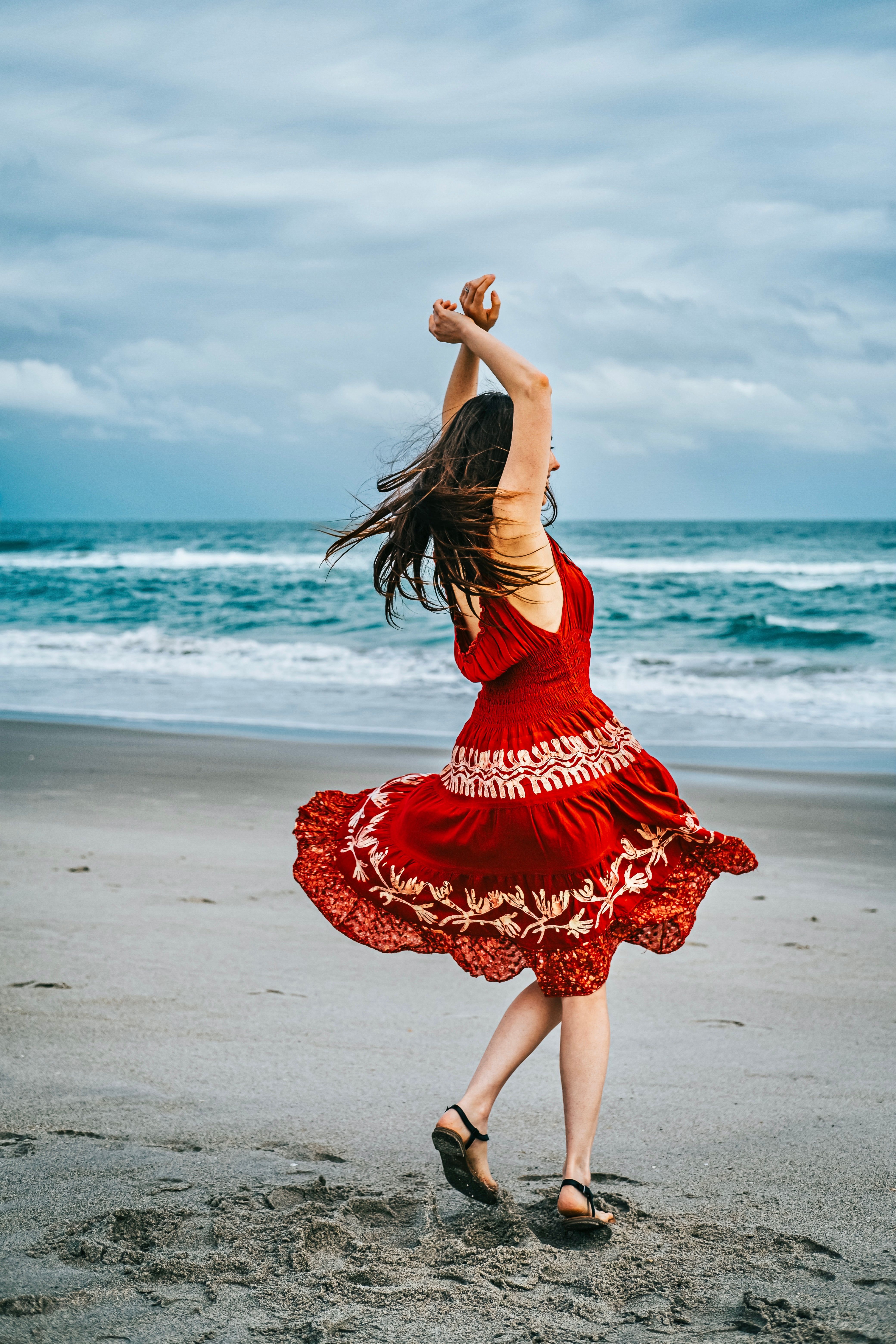 A Woman in Red Dress Standing on Beach  Free Stock Photo