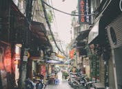 河内的小巷里遍布商店和摩托车，充满了活力的城市氛围