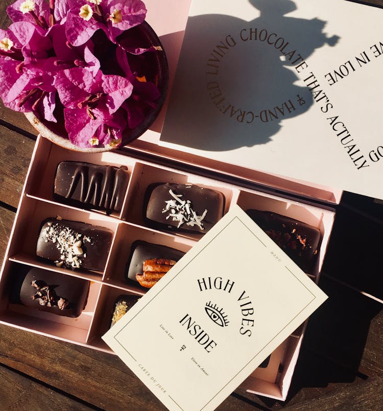 Box Of Chocolates Beside Bougainvillea Flower Arrangement