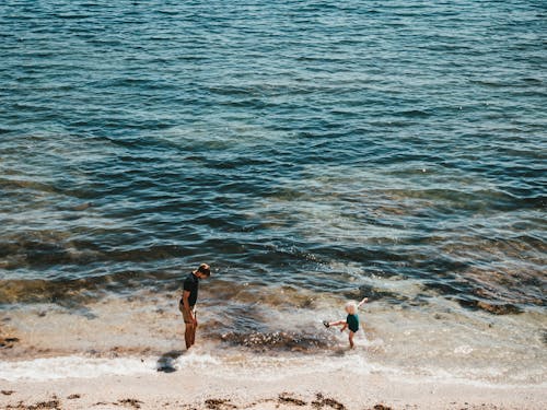Photo of Father and Child Playing in the Sea
