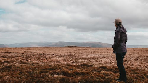 Person Standing on a Brown Field