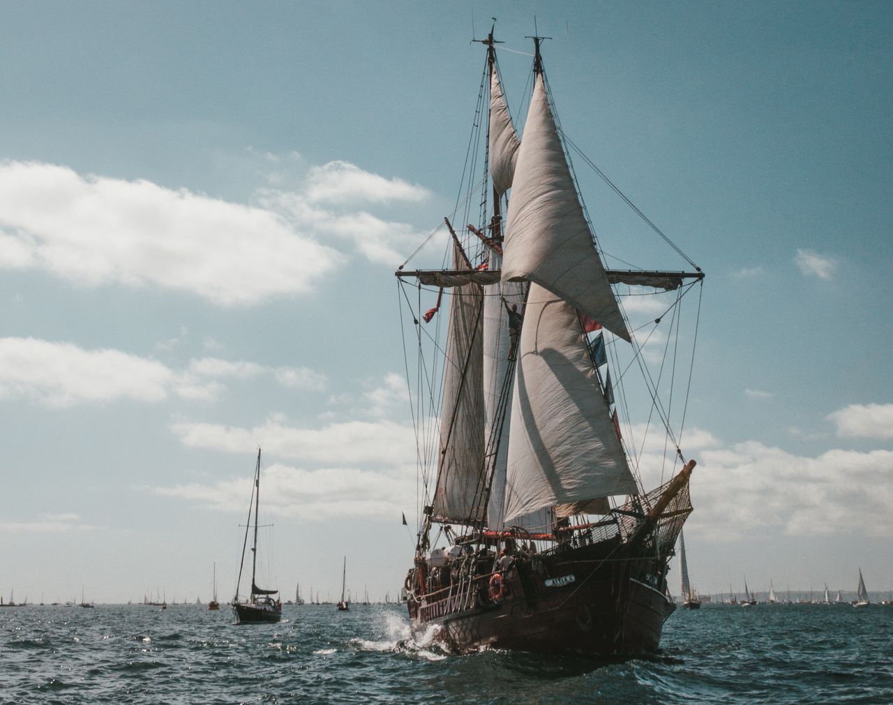 a breathtaking sailing ship glides through the falmouth sea under a cl