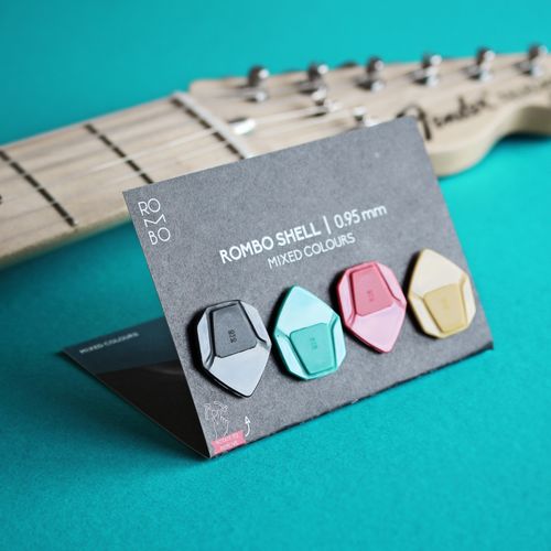 Free Close-up of colorful ROMBO guitar picks on a blue background with instrument. Stock Photo