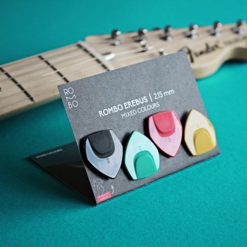 Free Variety of Rombo guitar picks on display with guitar neck in background. Perfect for music themes. Stock Photo