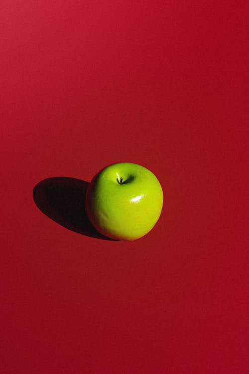 Green Apple on Red Background
