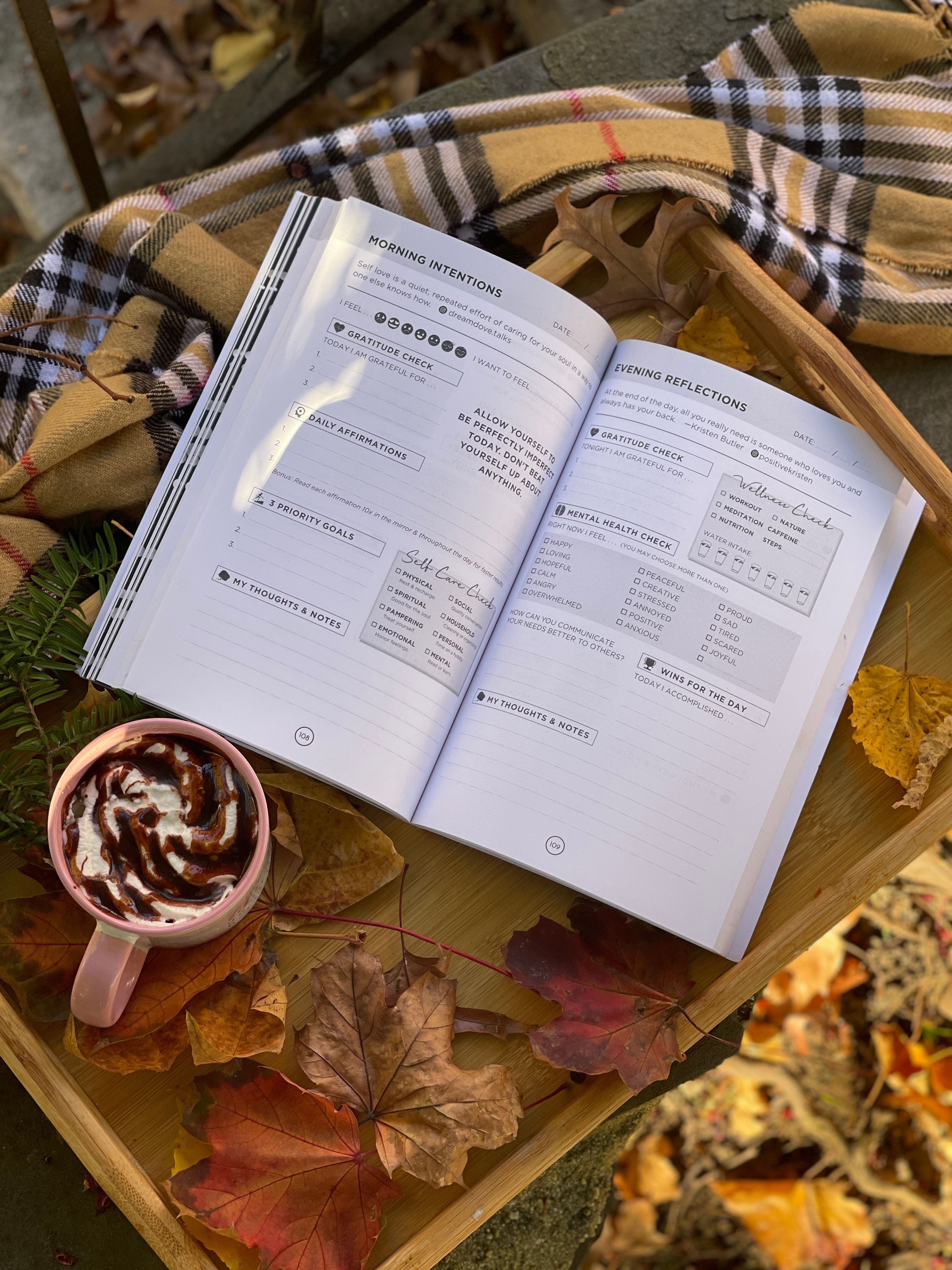 Capture the essence of fall with a journal and coffee surrounded by autumn leaves.