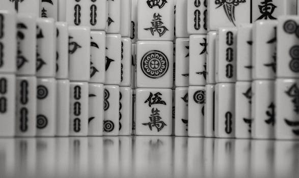 Detailed view of black and white Mahjong tiles neatly stacked, highlighting traditional Chinese characters and symbols.