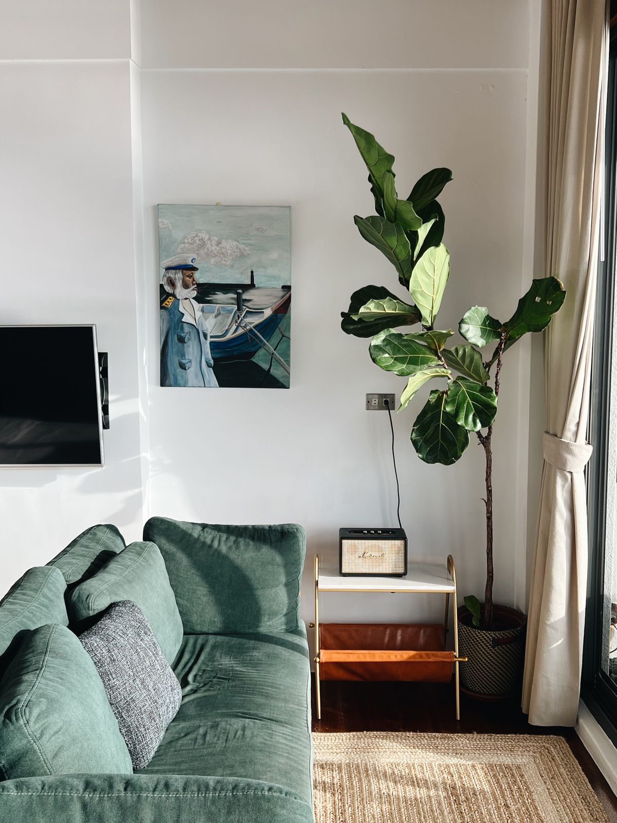Living room with green sofa plant and large wall art