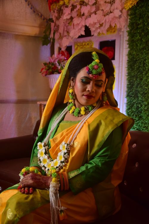 Free Captivating portrait of a woman posing in vibrant, traditional South Asian clothing adorned with floral jewelry. Stock Photo