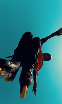 Low angle view of a skater jumping with vibrant blue sky in Abuja, Nigeria. Capturing youth culture and energy.