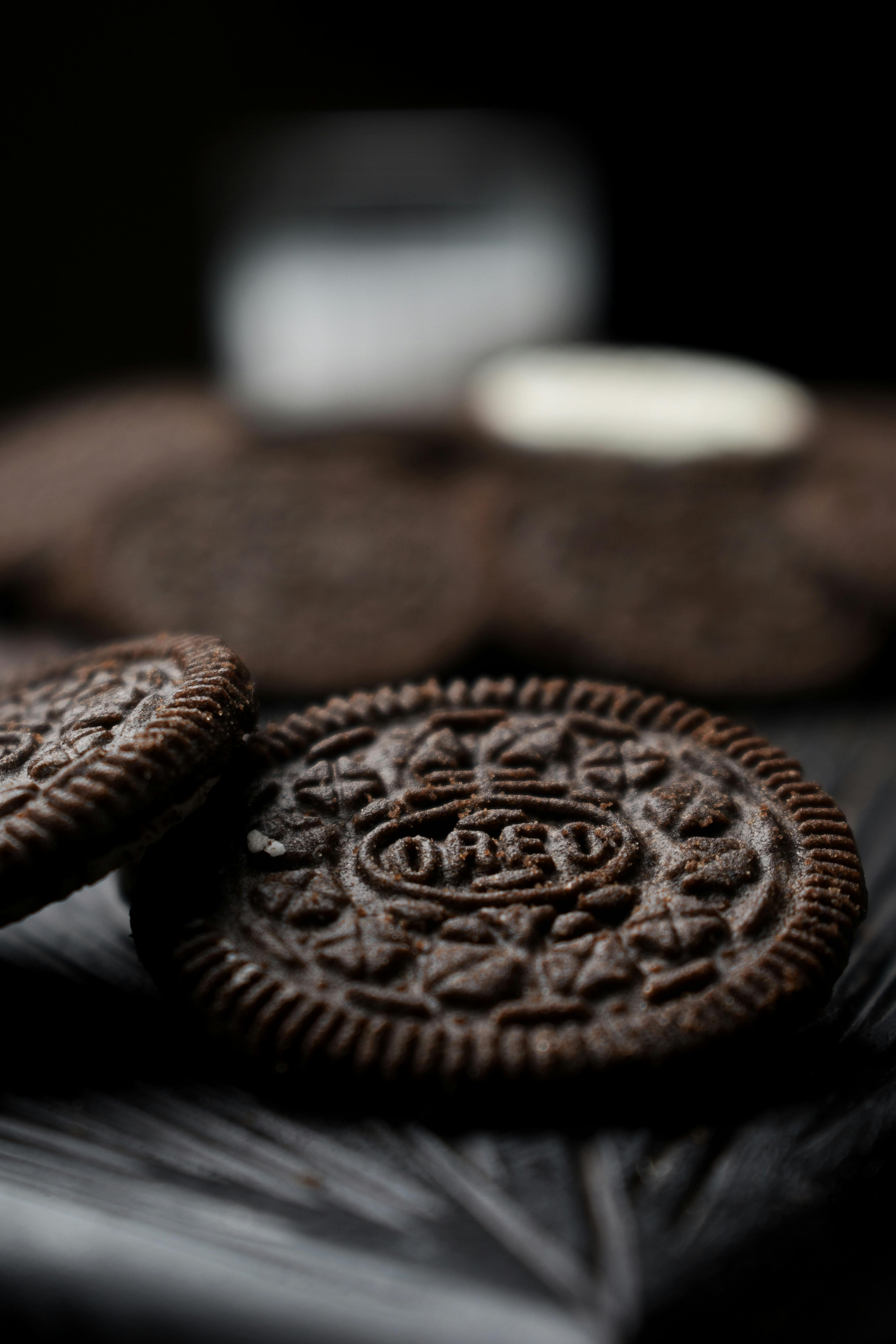 Premium Photo | Three oreo cookies are stacked on a blue surface.