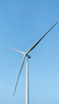 Close-up of a sleek wind turbine harnessing renewable energy against a clear blue sky.