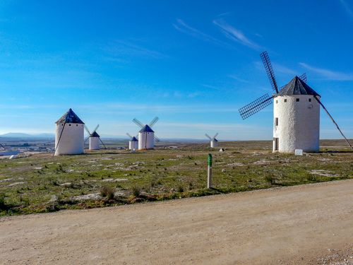 Free Scenic view of iconic windmills in Campo de Criptana under a clear blue sky. Stock Photo