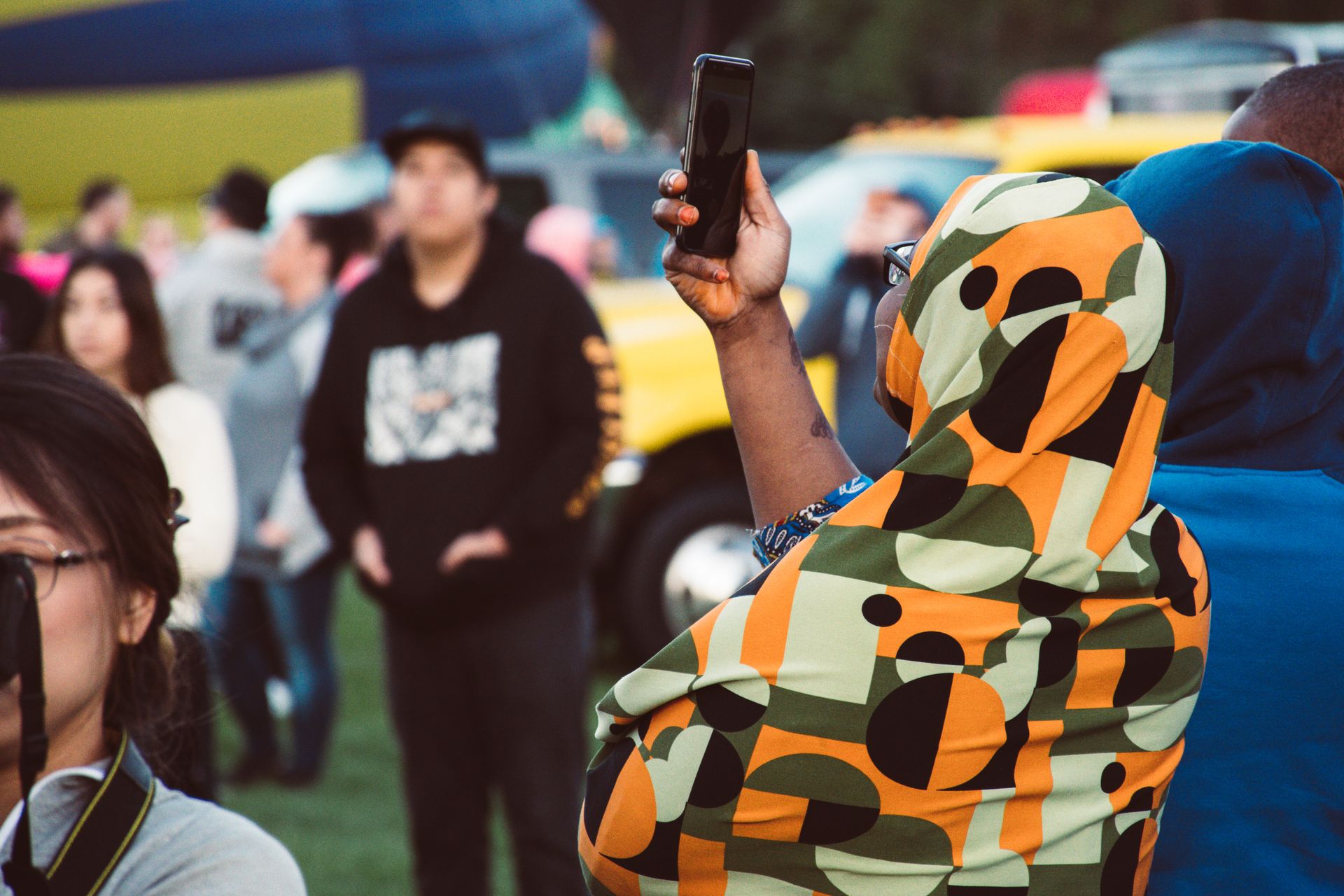 Vibrant festival scene with diverse people taking photos and enjoying the event.