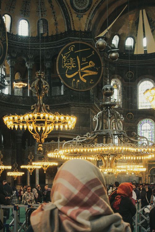 Free Captivating view inside Hagia Sophia Grand Mosque with ornate chandeliers and visitors in Istanbul. Stock Photo