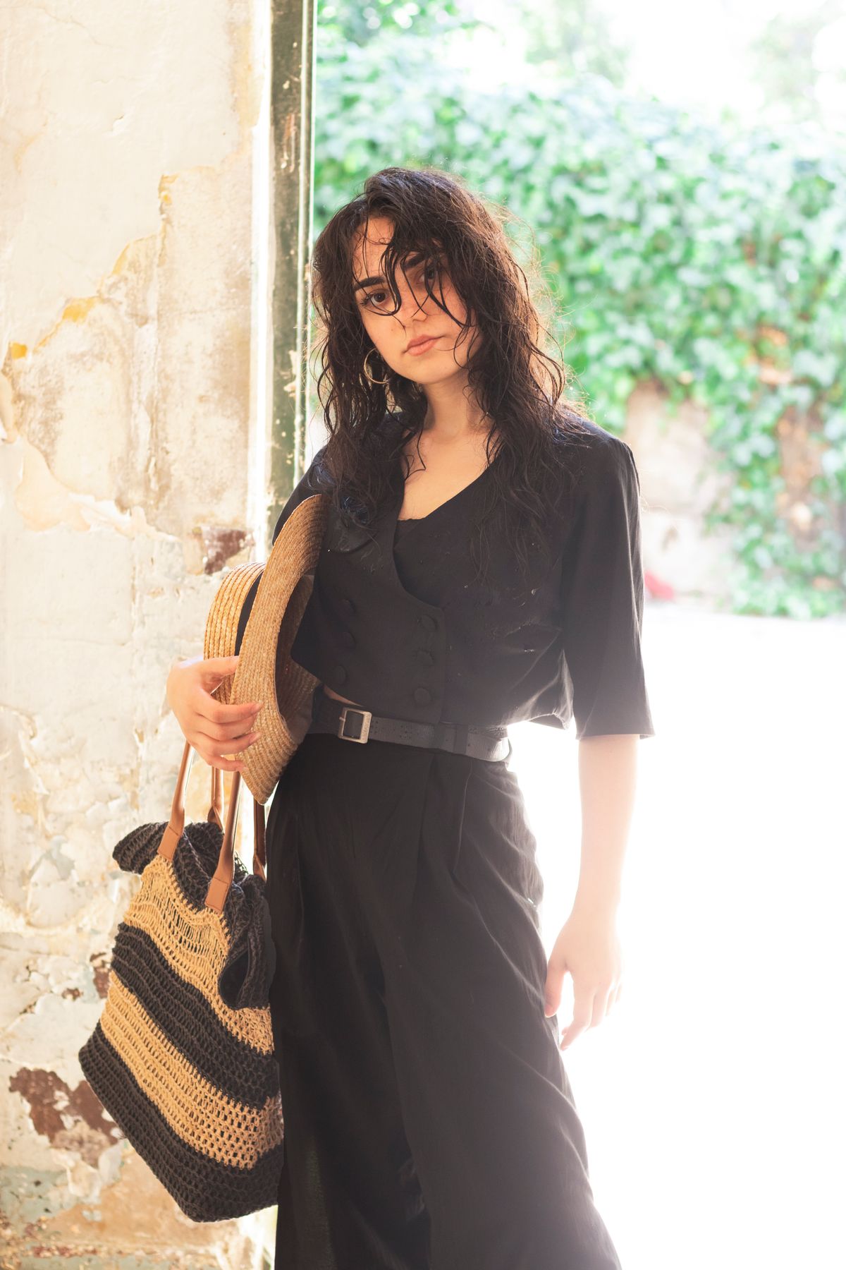 Woman in a summer dress carrying a raffia handbag