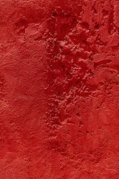 Bold red textured concrete wall showcasing rough surface ideal for design use.