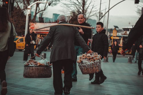 A Person Carrying Baskets of Assorted Goods