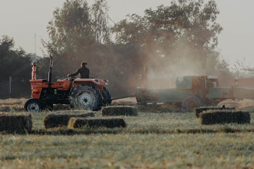 Man Working with Tractor on Field