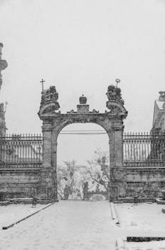 A classic view of a historic archway in Lviv, Ukraine, captured in a snowy, monochrome setting.