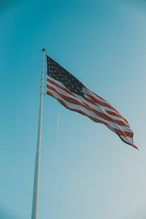 American Flag on Pole Under Blue Sky