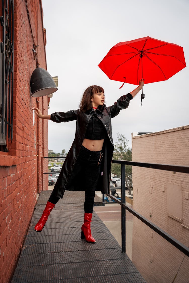 Woman With Red Umbrella On Balcony