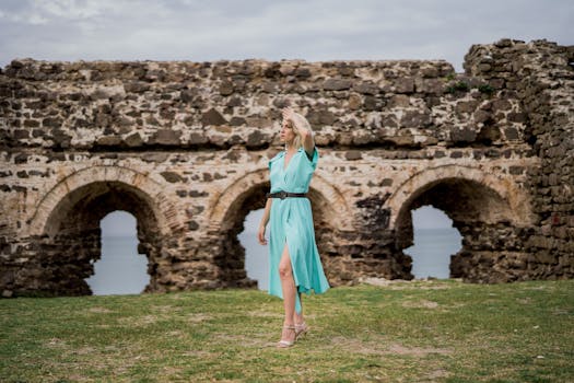 Blonde woman in green dress poses by historic stone ruins in Istanbul.