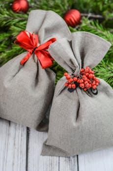 木制背景前，一个用红色蝴蝶结和浆果装饰的质朴亚麻礼品袋摆放着