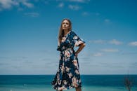 时尚的女人穿着花卉夏装在伊斯坦布尔的海边摆姿势，捕捉宁静而充满活力的夏日时刻