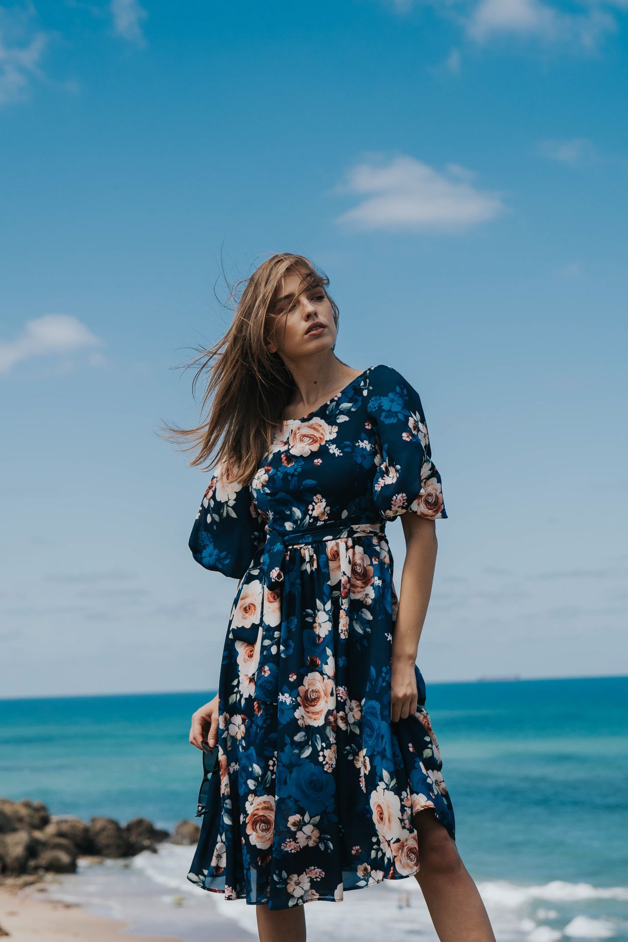 Woman wearing a floral-print midi dress on a beach