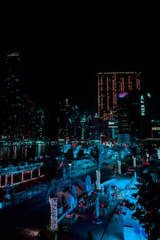 Stunning night cityscape of Dubai Marina with illuminated buildings and reflections on water.