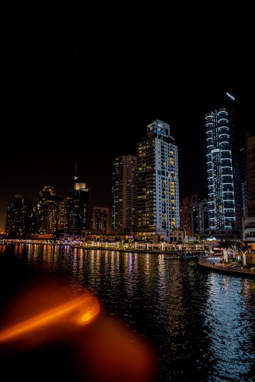 A city skyline at night with a river and buildings