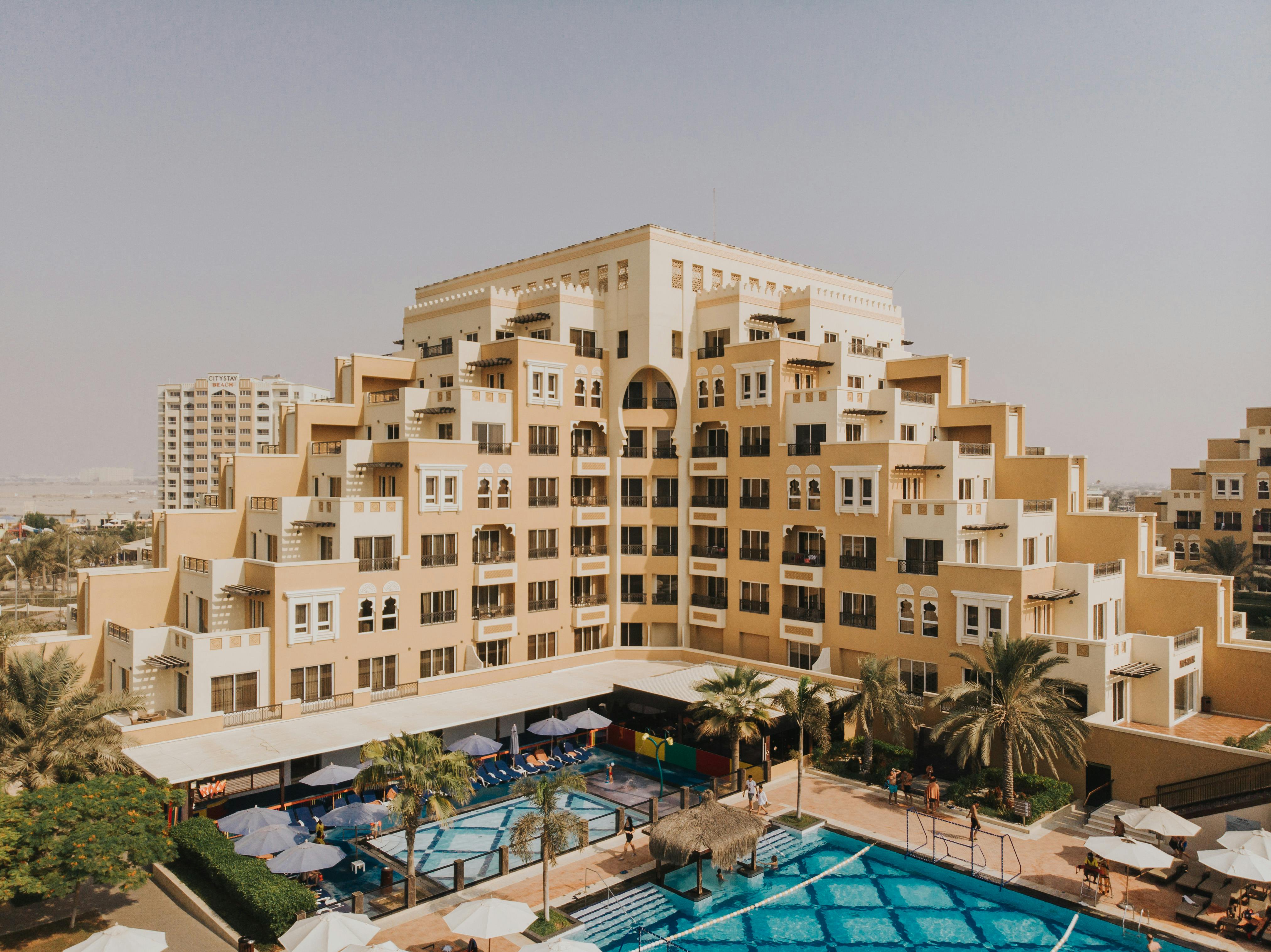 a hotel with a pool and a large building